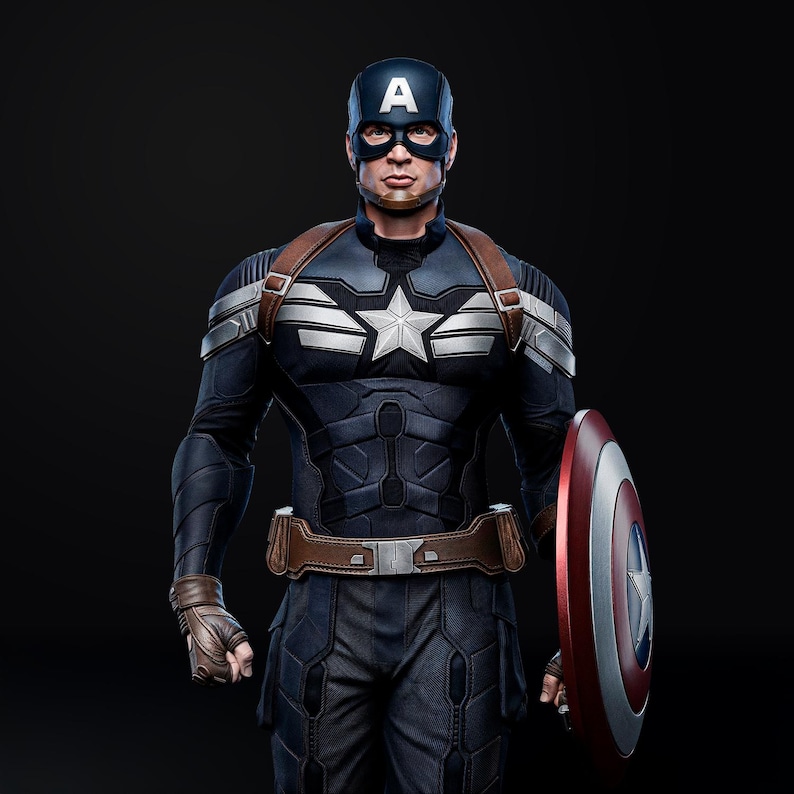 Op de afbeelding: Een Captain America-kostuum in marineblauw en zilver, met een wit sterembleem. De outfit bevat een blauwe helm met een witte "A", een bruine leren riem en een rood, wit en blauw schild. Het personage staat.