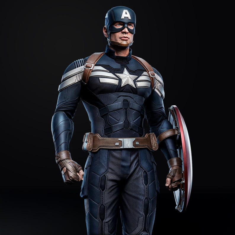 Op de afbeelding: Een Captain America actiefiguur in een donkerblauw en zilver kostuum, met een schild. De figuur heeft een helm met een witte "A" en een ster embleem op de borst. De figuur draagt een bruine riem en handschoenen.