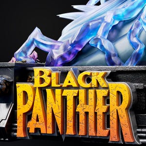 Pu&ograve; includere: Una scultura dettagliata con la scritta "BLACK PANTHER" in grandi lettere gialle, consumate, con un contorno nero e grigio. Sopra il testo c'&egrave; una struttura cristallina traslucida blu e viola.