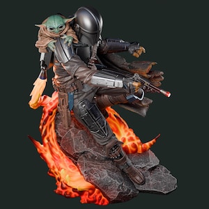 May include: A detailed statue of The Mandalorian, clad in dark armor, holding a blaster. Grogu, also known as Baby Yoda, is perched on his shoulder. The base features a fiery, orange and red lava effect, creating a dynamic action pose.