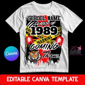 May include: A white t-shirt featuring a graphic design with the text SCHOOL NAME CLASS OF 1989 WARNING COMING THRU. The design includes yellow caution tape, two red emergency lights, and a tiger head illustration on a black and red background.