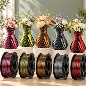 May include: Five spiraled vases in metallic magenta, lime green, bronze, charcoal, and red, each holding a bouquet of flowers. Below each vase sits a matching spool of 3D printer filament in the same metallic color, showing the material used.