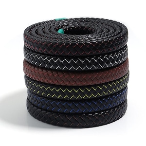 Peut inclure: Une pile de six cordons enroulés avec une texture tressée. Les cordons présentent des surfaces noires avec des couleurs d'accent distinctes tissées dans la tresse, notamment rouge, blanc, marron, jaune, bleu et un petit segment turquoise.