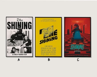May include: Three framed movie posters for "The Shining". The first is black and white with the title and images from the film. The second is yellow with the title and a face. The third is red with the title and a child on a tricycle.