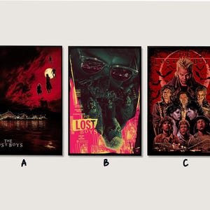 May include: Three framed movie posters for "The Lost Boys" are displayed. The posters feature dark, dramatic imagery with red and black color schemes. Each poster has the movie title at the bottom.
