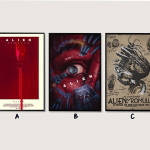 Puede incluir: Tres pósteres de película rectangulares para Alien: Romulus. El póster A presenta un fondo rojo con un haz de luz vertical. El póster B muestra un ojo humano grande con apéndices mecánicos. El póster C es un boceto beige con un cráneo y criatura.