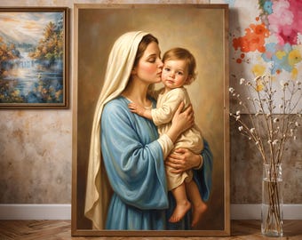 May include: A framed wall art print depicting a woman with a cream-colored head covering and a blue robe holding a small child in a cream-colored outfit. The woman is kissing the child on the cheek. The artwork is set against a neutral background.