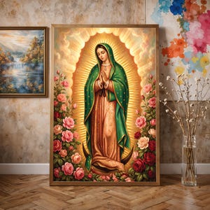 Puede incluir: Una impresión de arte mural vertical enmarcada que representa a la Virgen de Guadalupe con un manto verde sobre un vestido color melocotón, rodeada de rosas rosas y rojas, sobre un fondo de sol dorado radiante con nubes y una luna creciente.