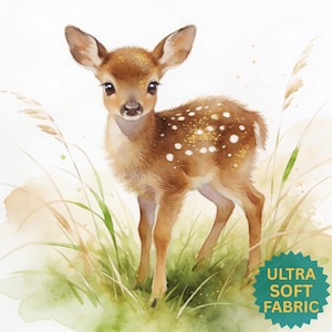May include: A watercolor illustration of a young brown fawn with white spots and gold glitter accents standing in green grass. The image features a teal star-shaped badge in the bottom right corner with the text ULTRA SOFT FABRIC.