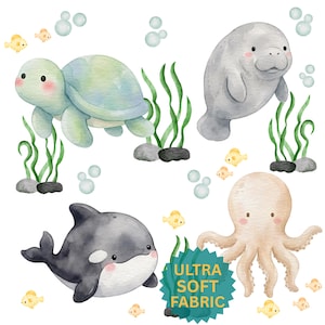 May include: Watercolor illustration featuring a sea turtle, manatee, orca, and octopus. The sea creatures are surrounded by seaweed, bubbles, and small yellow fish. The text "ULTRA SOFT FABRIC" is on a teal banner.