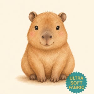 May include: A digital illustration of a brown capybara with a rounded body, small ears, and dark eyes. The capybara has soft fur and pink cheeks. A teal star-shaped badge in the bottom right corner features the text ULTRA SOFT FABRIC.