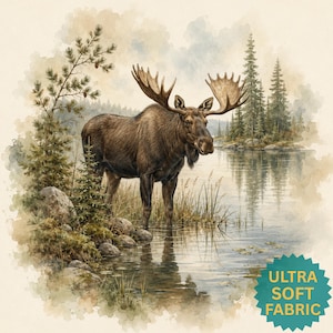 May include: A watercolour-style illustration of a brown moose standing in a lake near a rocky shoreline with pine trees. A teal star-shaped badge in the bottom right corner features the yellow text ULTRA SOFT FABRIC.