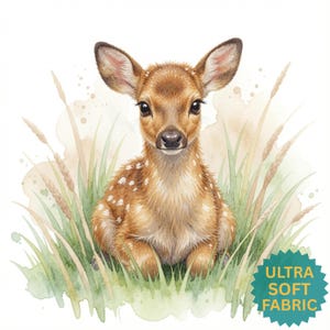 May include: A watercolor illustration of a brown fawn with white spots sitting in green grass and tall wheat stalks. A teal star-shaped badge in the bottom right corner features the yellow text "ULTRA SOFT FABRIC" in a sans-serif font.