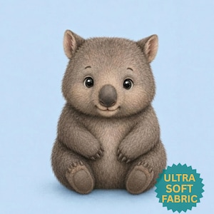 May include: A brown, furry wombat illustration with large dark eyes and a small nose, sitting in a front-facing position. A teal star-shaped badge in the bottom right corner features the yellow text, ULTRA SOFT FABRIC.