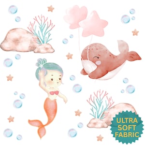 May include: Watercolor illustration featuring a mermaid, whale with balloons, coral, and bubbles. The mermaid has teal hair and an orange tail. The whale holds two pink balloons. The image has a soft, pastel color palette and the text "ULTRA SOFT FABRIC".