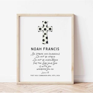 May include: Framed print featuring a soccer ball cross design. The print includes the name "Noah Francis" and a religious quote from Joshua 1:9. The date "April 18th, 2026" is also included.