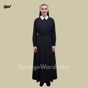 May include: A black habit with a white collar and head covering. The long-sleeved dress has a matching belt. The text "SavageWardrobe" is printed on the bottom of the image. The nun's habit is a traditional religious garment.