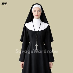 May include: A black and white nun costume with a long black dress, white collar, and a black veil. A white head covering and a cross pendant necklace complete the outfit. The text "SavageWardrobe" is visible on the garment.