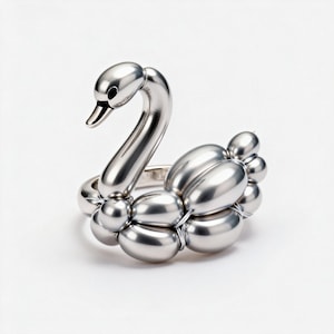 May include: A silver-toned ring featuring a sculptural swan design that mimics the appearance of a balloon animal. The swan has a smooth, reflective metallic surface with rounded, bulbous segments forming the body and a curved neck.