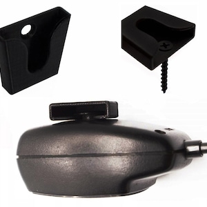 May include: A selection of black mounting brackets and a microphone. The brackets are designed to hold an object, with one including a screw for installation. The microphone is oval-shaped with a rectangular top.