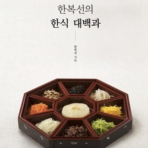 Puede incluir: Una portada de libro que muestra una bandeja de servir octogonal de color marrón oscuro con ocho compartimentos llenos de varios ingredientes coloridos, incluyendo zanahorias ralladas, tiras de huevo y verduras, alrededor de un alimento blanco redondo.