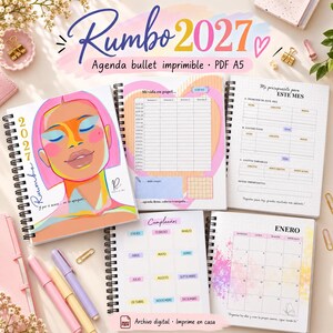 Op de afbeelding: Een printbare 2027 bullet journal planner met spiraalbinding. De kaft bevat een kleurrijke illustratie van een gezicht. De binnenpagina's bevatten een maandkalender voor januari, een budgettracker, een verjaardagslijst en weekplanningen.