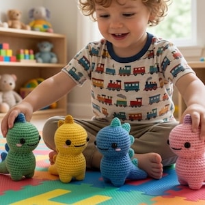 Puede incluir: Cuatro juguetes de dinosaurios de ganchillo en verde, amarillo, azul y rosa. Los juguetes tienen pequeños ojos negros y una expresión amigable. El niño lleva una camiseta de manga corta con un estampado de trenes. Los juguetes probablemente son de hilo.