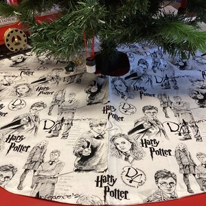 May include: A white Christmas tree skirt with a black and white print of Harry Potter characters and the words "Harry Potter" and "D.A." repeated throughout.