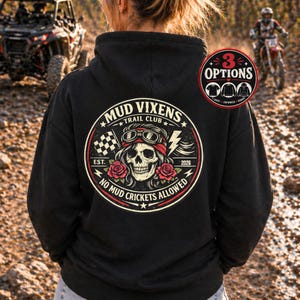 Könnte beinhalten: Schwarzer Kapuzenpullover mit einem kreisförmigen Aufdruck auf dem Rücken. Der Aufdruck zeigt einen Totenkopf mit Brille und Bandana, umgeben von Text, der "MUD VIXENS TRAIL CLUB" und "NO MUD CRICKETS ALLOWED" lautet. Ein kleines "3 OPTIONS"-Grafik ist ebenfalls sichtbar.