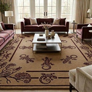 Könnte beinhalten: Ein großer, rechteckiger Teppich mit beigem Hintergrund und einem sich wiederholenden Muster aus dunkelbraunen Eidechsen. Der Teppich befindet sich in einem Wohnzimmer mit burgunderfarbenen Sofas, einem Couchtisch und Tageslicht.