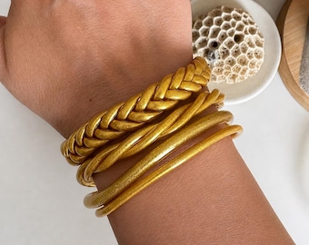 Set of 4 soft plastic bracelets in a gold Buddhist bangle style