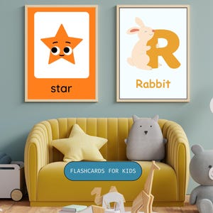 May include: Two framed educational wall art prints for children. The left print features an orange star with a face and the text star. The right print shows a light pink rabbit hugging a large orange letter R with the text Rabbit below it.