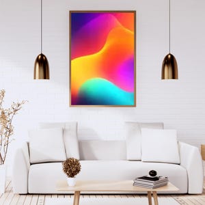 May include: A framed abstract art print with a vibrant, colorful design. The artwork features a gradient of colors, including purple, orange, yellow, and teal. The print is displayed in a modern living room setting with a white sofa and wooden coffee table.