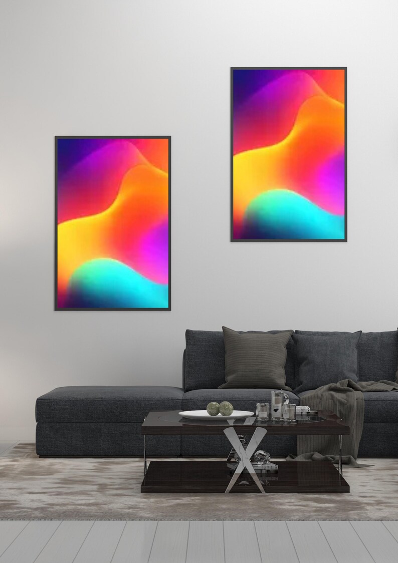 May include: Two framed abstract art prints with vibrant colors of purple, yellow, orange, and teal. The artwork features flowing, wave-like shapes. The prints are displayed above a dark gray sofa in a modern living room setting.