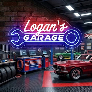 May include: A neon sign that reads "Logan's Garage" in white script, outlined in blue, shaped like a wrench. The garage features a red classic car, a green car, tool cabinets, and diagnostic equipment.