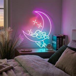 Könnte beinhalten: Ein Neon-Schild in Form einer Mondsichel mit einem Farbverlauf in Pink und Blau. Das Design zeigt stilisierte Wolkenformen und vierzackige Sternakzente. Das Schild ist an einer Wand über einer Holzoberfläche montiert und strahlt sanft.