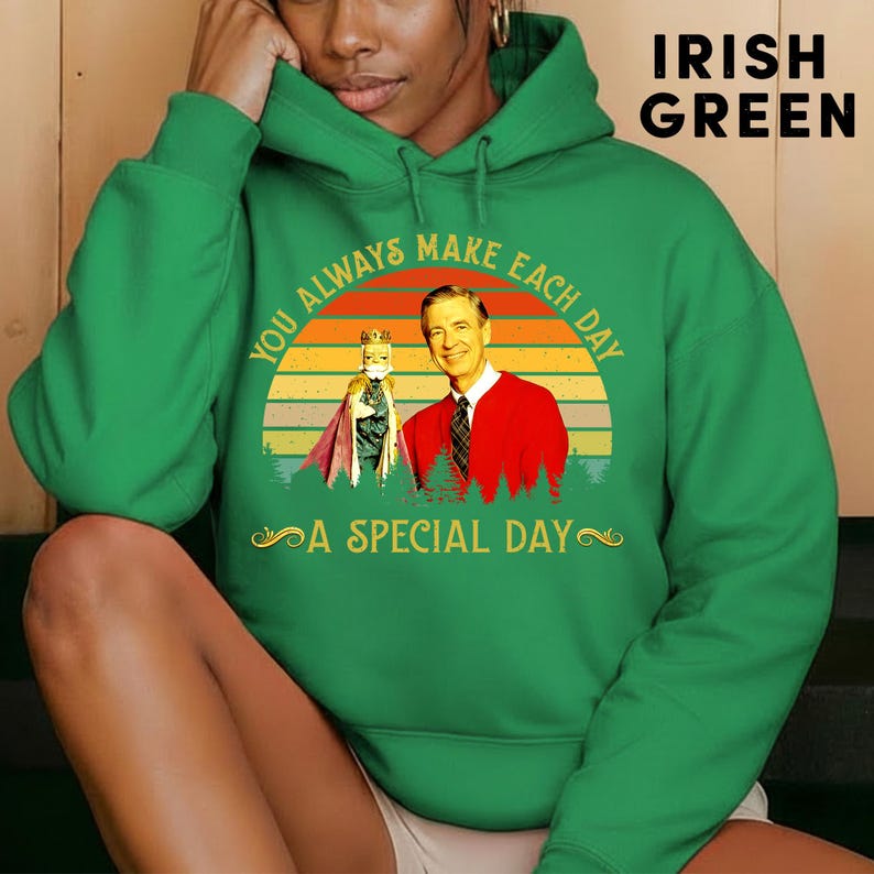 May include: Irish green hoodie with a graphic featuring a vintage sunset design with the text "You Always Make Each Day A Special Day". The graphic includes an image of a man in a red sweater and a puppet.