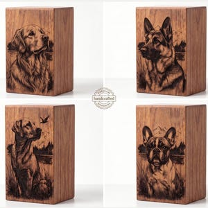 May include: Four rectangular wooden urns featuring laser-engraved portraits of different dog breeds. Each box displays a detailed illustration of a canine set against a natural landscape background. A circular stamp in the center reads Premium handcrafted.