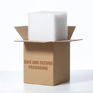 Puede incluir: Una caja de env&iacute;o de cart&oacute;n marr&oacute;n con solapas abiertas, que contiene un gran bloque cuadrado de pl&aacute;stico de burbujas blanco. El frente de la caja presenta el texto SAFE AND SECURE PACKAGING impreso en una fuente negrita, marr&oacute;n y sin remates.