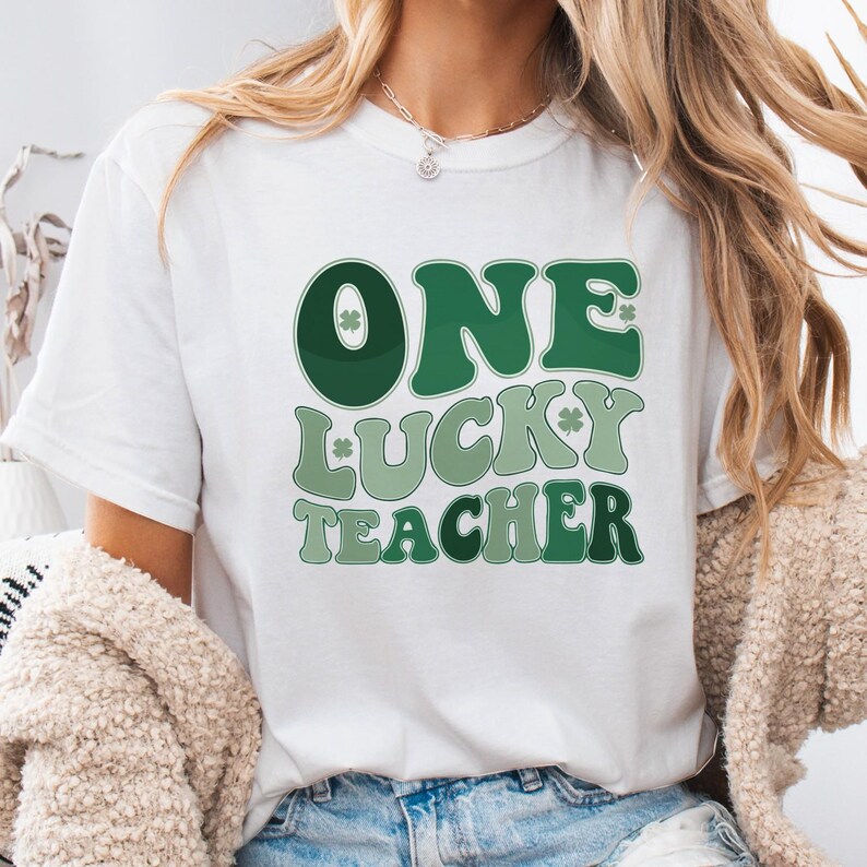 White - colored Comfort Colors 1717 tee with "One Lucky Teacher" shamrock graphic. Soft, garment-dyed teacher appreciation shirt, aesthetic St. Patrick's Day look for women.