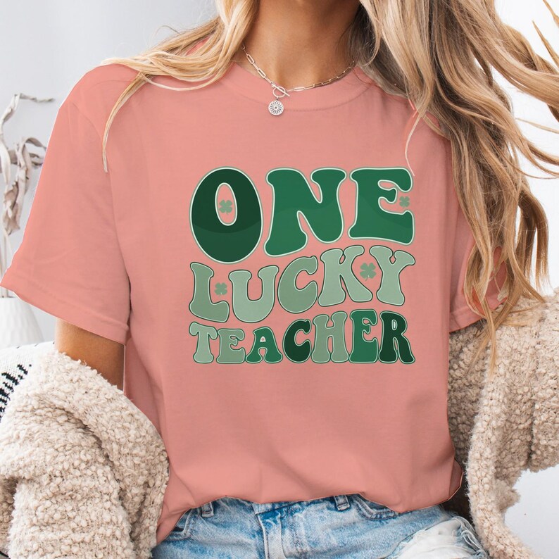 Terracotta - colored Comfort Colors 1717 tee with "One Lucky Teacher" shamrock graphic. Soft, garment-dyed teacher appreciation shirt, aesthetic St. Patrick's Day look for women.