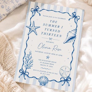 May include: A rectangular invitation card with a light blue and white striped background. The border features blue ribbons with bows, a starfish, a seashell, coral, and a sand dollar. Text reads: PLEASE JOIN US TO CELEBRATE THE SUMMER I TURNED THIRTEEN HONORING Olivia Rose SATURDAY, AUGUST 10TH AT 12PM THE OCEANVIEW HOUSE 123 SEASIDE DRIVE DESTIN, FL 32541 RSVP TO JENNIFER AT 850-555-7842 BY JULY 25TH.