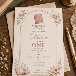 May include: A rectangular invitation card featuring a gold arched frame, pink floral illustrations, and a small book icon. The text reads: Once Upon a Time, Olivia turned one, join us to celebrate, Sunday June 6 2027 at 3:00 PM, Lavender House, 29 Orchard Lane, Your City, ST 12345, RSVP Ella at 555-7319.