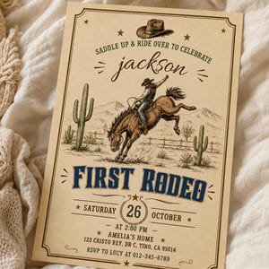 May include: A rectangular invitation card with a cream-colored background featuring a western theme. It displays a cowboy riding a bucking horse, cacti, and a hat illustration. Text includes SADDLE UP & RIDE OVER TO CELEBRATE, jackson, FIRST RODEO, SATURDAY 26 OCTOBER, AT 2:00 PM, AMELIA'S HOME, 123 CRISTO REY, DR C, TINO, CA 95014, and RSVP TO LUCY AT 012-345-6789.