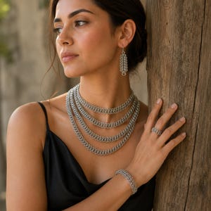 Peut inclure: Un ensemble de bijoux en cotte de mailles argent&eacute;e compos&eacute; d'un collier &agrave; plusieurs rangs, d'une paire de boucles d'oreilles pendantes rectangulaires, d'un bracelet assorti et d'une bague. Chaque pi&egrave;ce pr&eacute;sente un motif de maillons m&eacute;talliques.