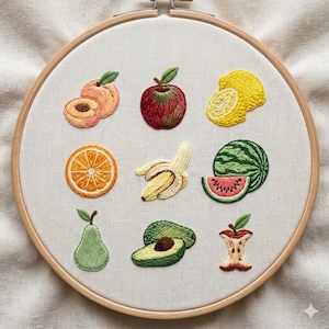 Puede incluir: Un bastidor de bordado con bordados de frutas coloridas. El diseño incluye un melocotón, una manzana, un limón, una rodaja de naranja, un plátano, una sandía, una pera, un aguacate y un corazón de manzana. Las frutas están bordadas con texturas detalladas y colores vibrantes.