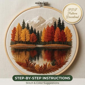 May include: An embroidery hoop containing a landscape scene of autumn trees, a lake, and mountains. The design features yellow, orange, and red foliage with dark green pine trees. A circular badge reads PDF Pattern Download. Text below reads STEP-BY-STEP INSTRUCTIONS Stitch & Color Suggestions.