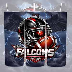 May include: A tumbler featuring a football helmet and football with the word "FALCONS" in white. The design includes a black eagle with red eyes, wings, and lightning bolts against a dark background. The tumbler is cylindrical.