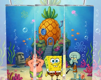 May include: A stainless steel tumbler featuring a vibrant underwater scene with cartoon characters. The design includes SpongeBob SquarePants, Patrick Star, Squidward, and the pineapple house. The background is a bright blue ocean with coral and fish.