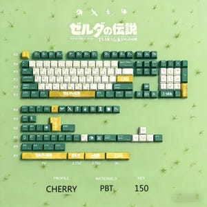 Może przedstawiać: Zestaw 150 klawiszy Cherry profile PBT w kolorach zielonym, białym i złotym, z japońskim tekstem i motywami z Zeldy. Klawisze są ułożone na jasnozielonej powierzchni z akcentami trawy. Widoczny jest tekst "The Legend of Zelda Tears of the Kingdom".